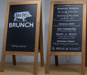 Sidewalk Chalkboard Sign for the Hog Pit Restaurant in New York new York. A-Frame with black and white art with stained walnut framing.